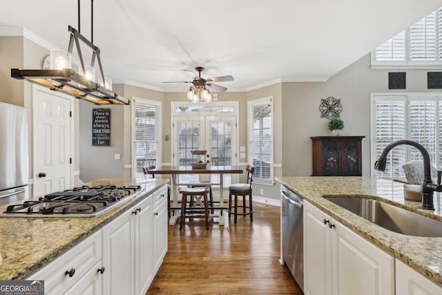 kitchen featuring white cabinetry, appliances with stainless steel finishes, sink, and hanging light fixtures