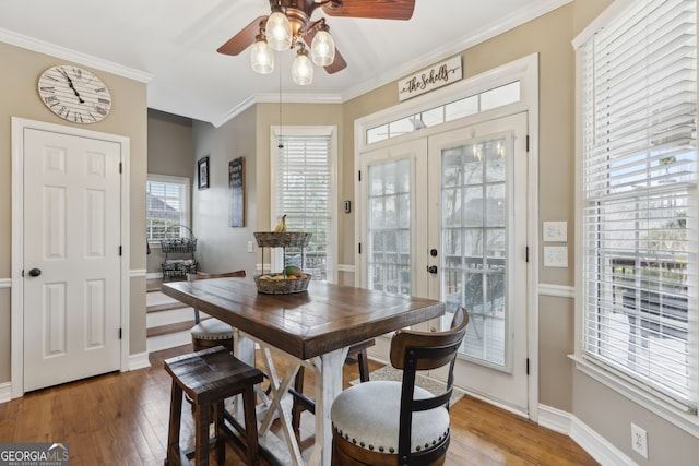 dining space with ornamental molding, hardwood / wood-style floors, ceiling fan, and french doors