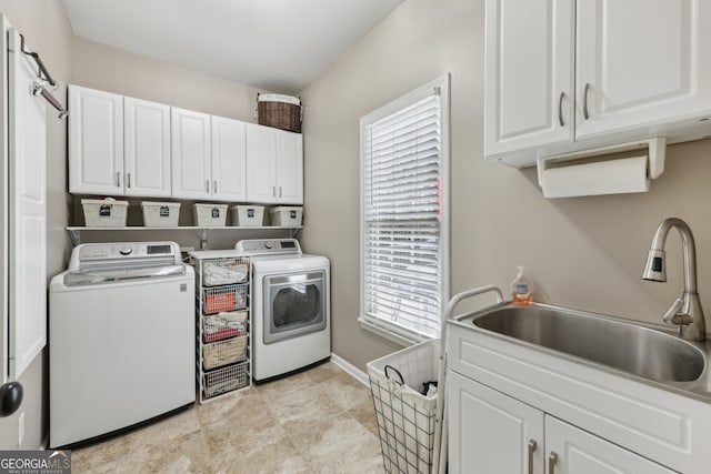 laundry room featuring cabinets, a healthy amount of sunlight, sink, and washing machine and dryer