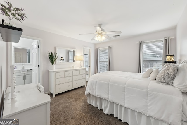 carpeted bedroom featuring ceiling fan, sink, and ensuite bath