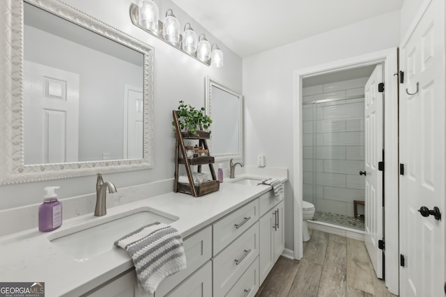 bathroom with walk in shower, vanity, toilet, and hardwood / wood-style floors