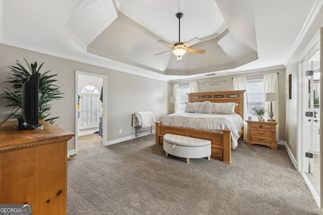 carpeted bedroom with crown molding, a tray ceiling, and ceiling fan