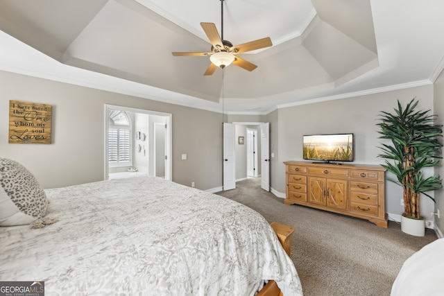 carpeted bedroom with crown molding, connected bathroom, a tray ceiling, and ceiling fan