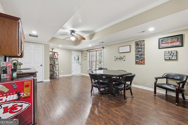 dining area featuring sink, crown molding, ceiling fan, a tray ceiling, and dark hardwood / wood-style flooring