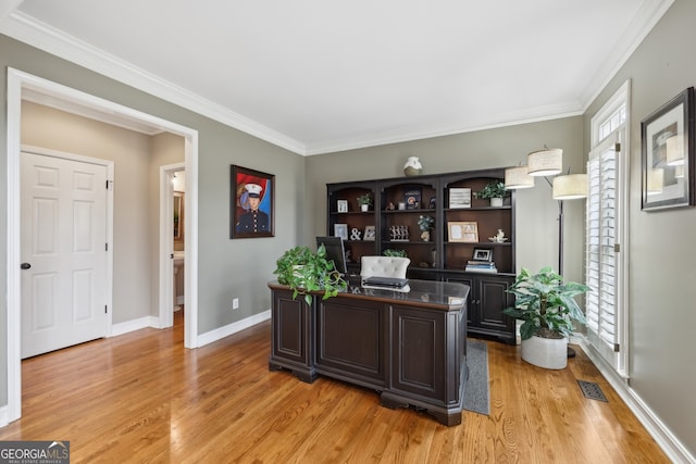 home office with crown molding, plenty of natural light, and light hardwood / wood-style floors