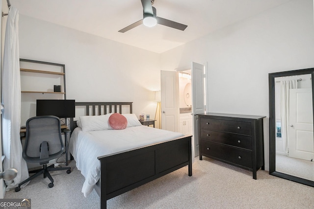 bedroom featuring ensuite bathroom, light carpet, and ceiling fan