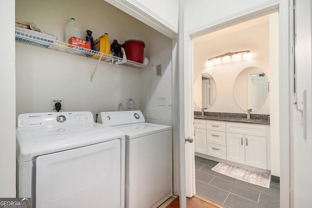 laundry area featuring washer and clothes dryer and dark tile patterned flooring