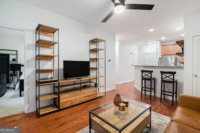 living room with light hardwood / wood-style flooring and ceiling fan