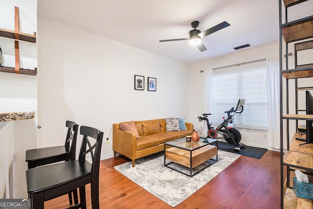 living room featuring wood-type flooring and ceiling fan