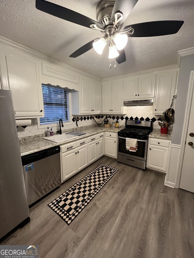 carpeted bedroom featuring ceiling fan and a textured ceiling