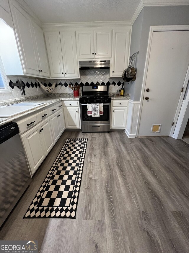 kitchen featuring sink, stainless steel fridge, white cabinets, a drop ceiling, and light hardwood / wood-style flooring