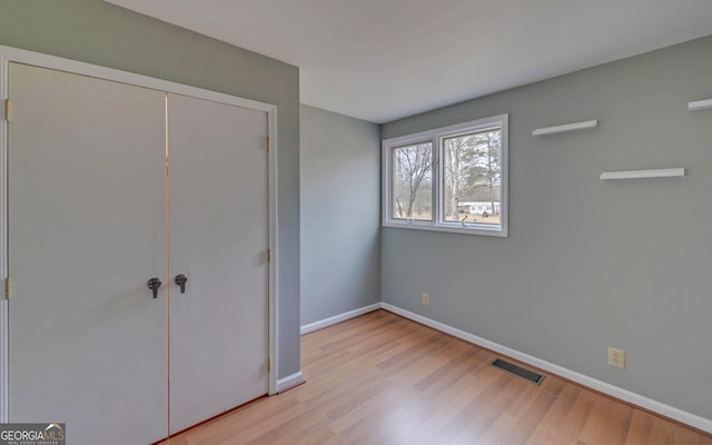 unfurnished bedroom featuring a closet and light hardwood / wood-style flooring