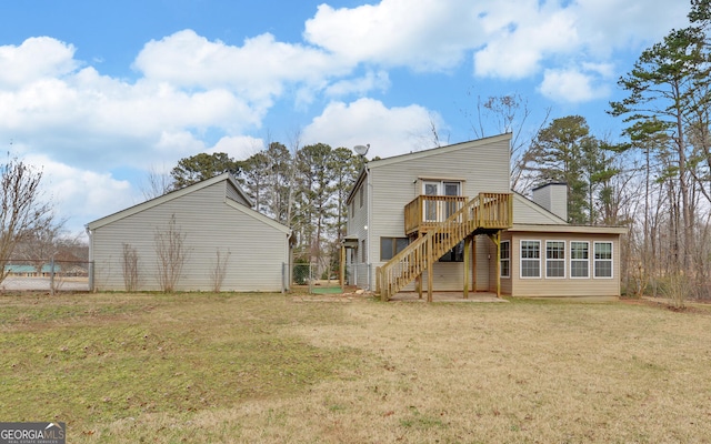 back of house with a wooden deck and a yard