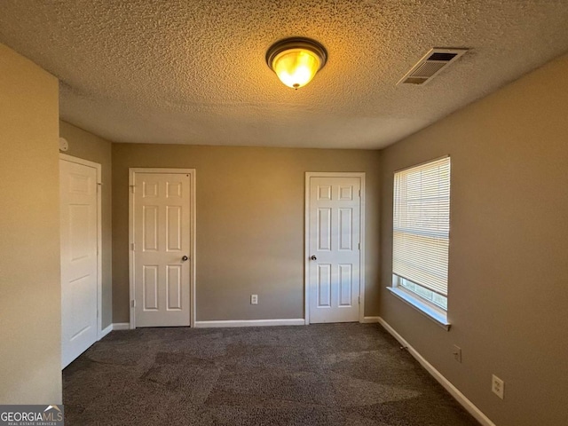 carpeted spare room featuring a healthy amount of sunlight and a textured ceiling