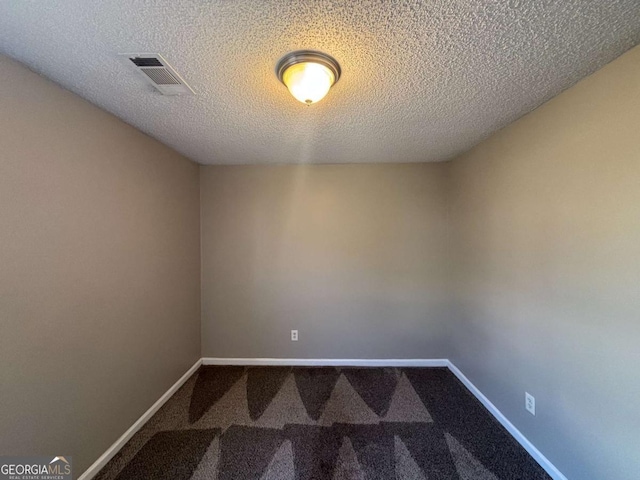 spare room featuring carpet flooring and a textured ceiling