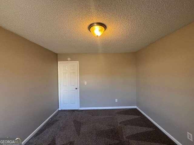 carpeted spare room with a textured ceiling