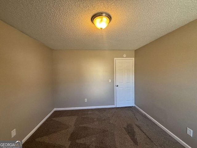 spare room with a textured ceiling and carpet flooring