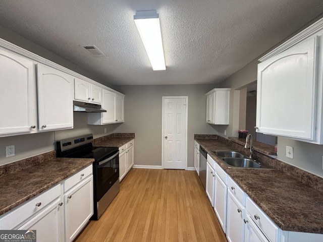 kitchen featuring appliances with stainless steel finishes, white cabinetry, sink, light hardwood / wood-style floors, and a textured ceiling