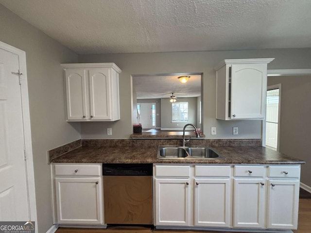 kitchen with white cabinetry, dishwasher, sink, and a textured ceiling