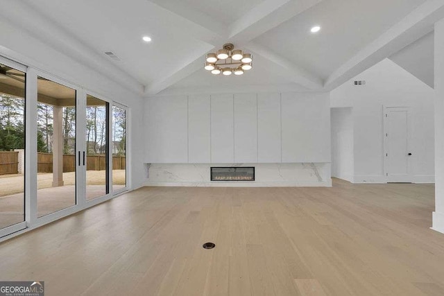 unfurnished living room with beamed ceiling, a chandelier, and light wood-type flooring