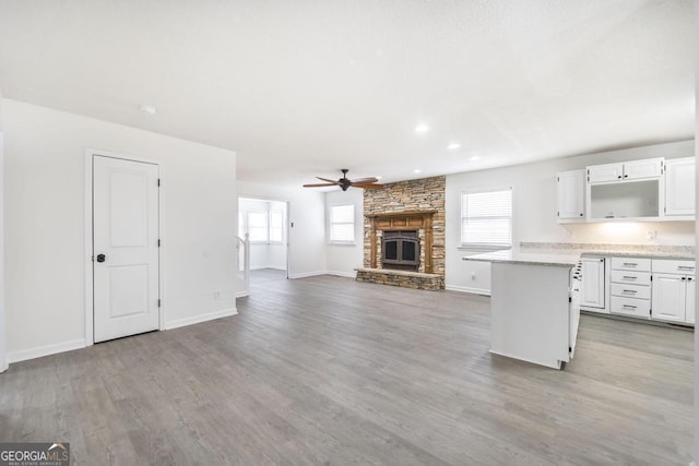 kitchen with a healthy amount of sunlight, a fireplace, hardwood / wood-style floors, and white cabinets