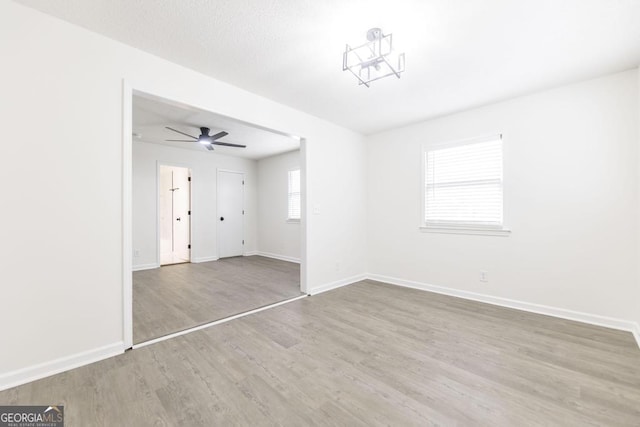 spare room featuring a wealth of natural light, ceiling fan, and light hardwood / wood-style flooring