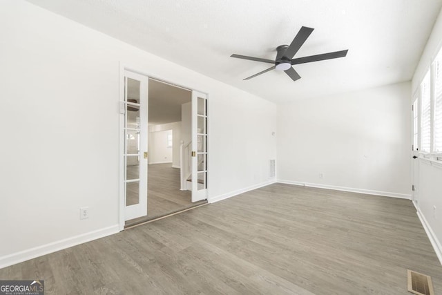 spare room with hardwood / wood-style floors, ceiling fan, and french doors