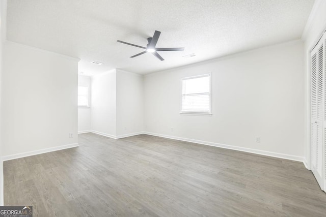 spare room with hardwood / wood-style flooring, crown molding, a healthy amount of sunlight, and ceiling fan