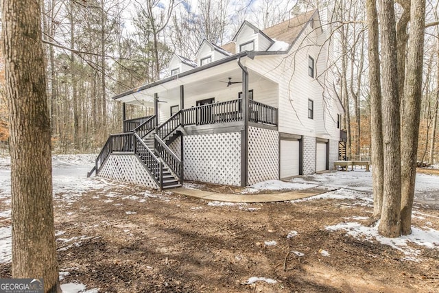 snow covered property featuring a porch and a garage