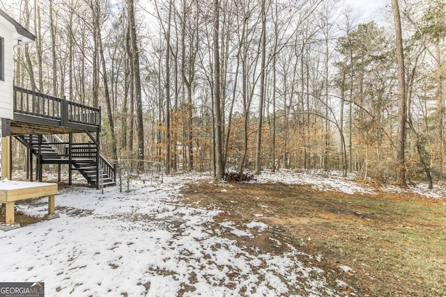 yard covered in snow with a wooden deck