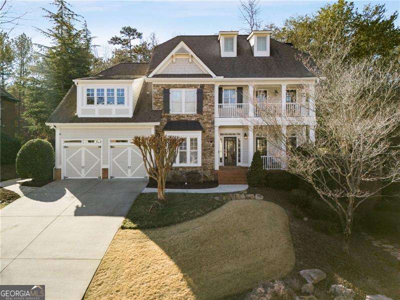 view of front of property with a garage, a balcony, and a front lawn