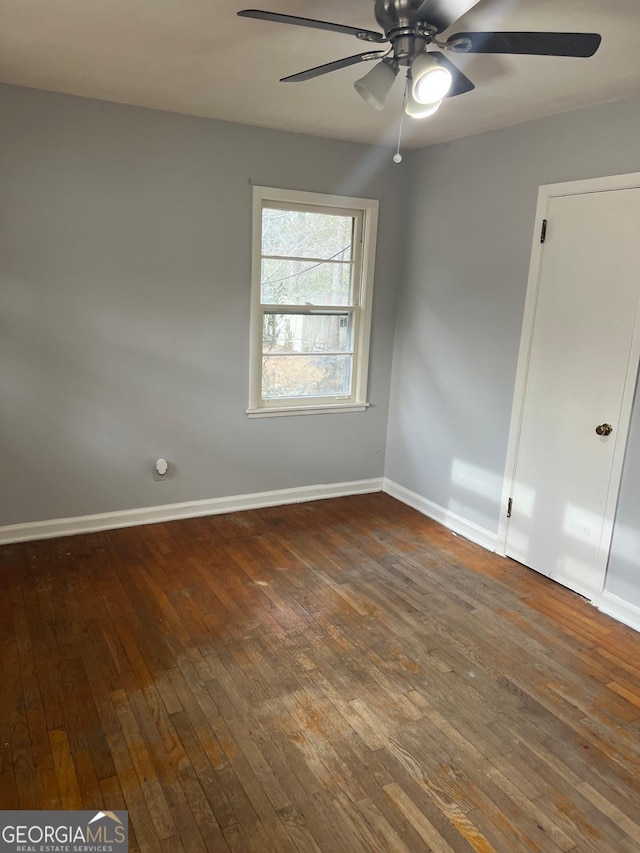 empty room with ceiling fan and dark hardwood / wood-style floors