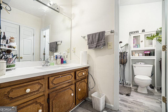 bathroom featuring vanity, hardwood / wood-style floors, and toilet