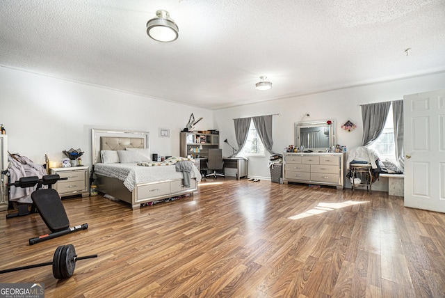 bedroom with hardwood / wood-style floors and a textured ceiling