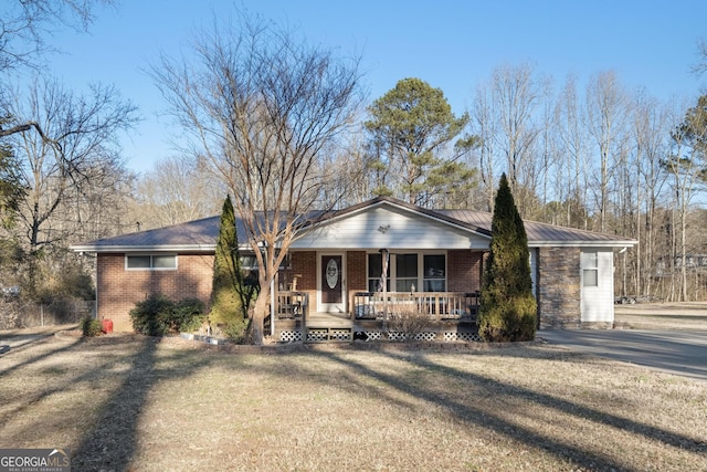 single story home with a porch and a front lawn