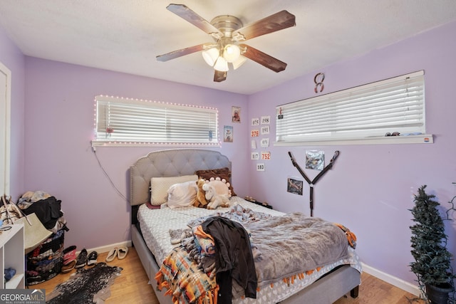 bedroom with light hardwood / wood-style flooring and ceiling fan