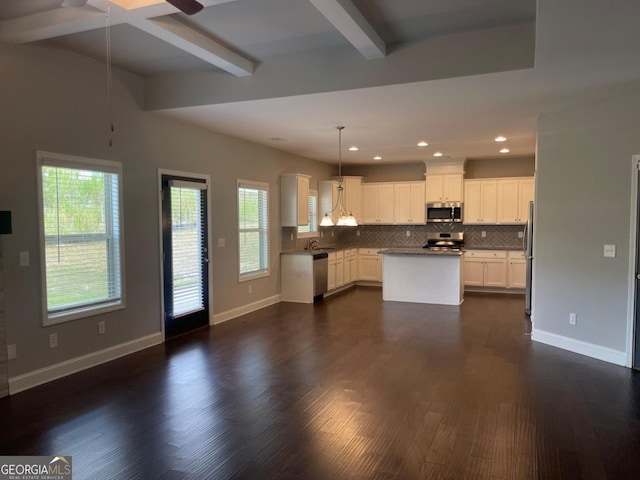 kitchen with white cabinets, hanging light fixtures, a center island, stainless steel appliances, and beam ceiling