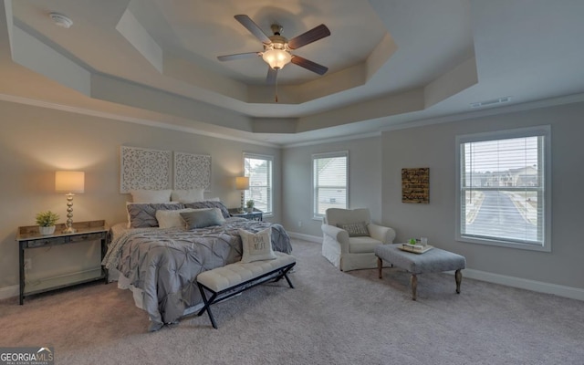 carpeted bedroom featuring a raised ceiling, crown molding, ceiling fan, and multiple windows