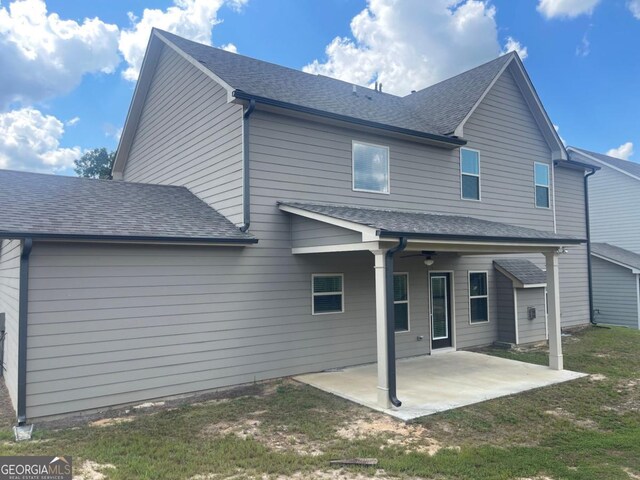 rear view of house with a yard and a patio