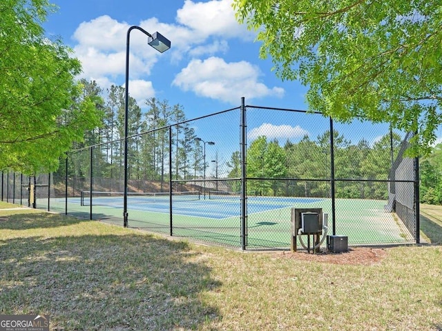 view of sport court with a yard