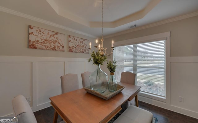 dining room with crown molding, dark hardwood / wood-style floors, a raised ceiling, and a chandelier