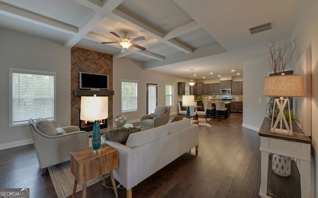 living room featuring coffered ceiling, a large fireplace, and beamed ceiling