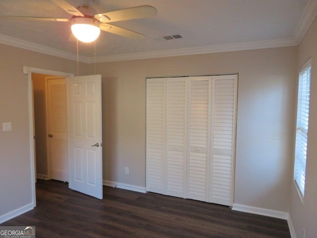 unfurnished bedroom with a closet, ornamental molding, dark hardwood / wood-style floors, and ceiling fan