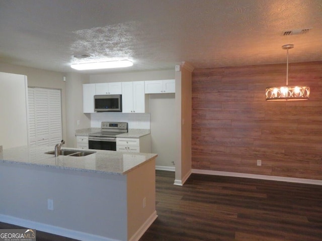 kitchen with decorative light fixtures, white cabinetry, sink, stainless steel appliances, and light stone countertops