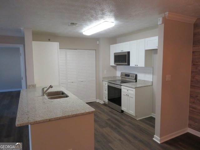 kitchen with stainless steel appliances, sink, white cabinets, and kitchen peninsula