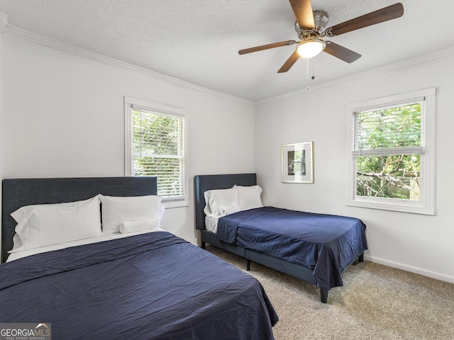 carpeted bedroom with crown molding, a textured ceiling, and ceiling fan