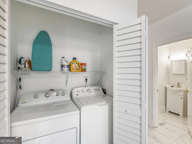 laundry room featuring crown molding, separate washer and dryer, and sink