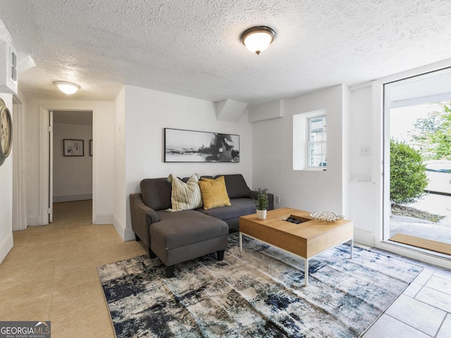 living room featuring a textured ceiling and light tile patterned floors