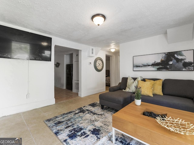 tiled living room featuring a textured ceiling