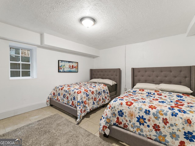 bedroom featuring light tile patterned flooring and a textured ceiling